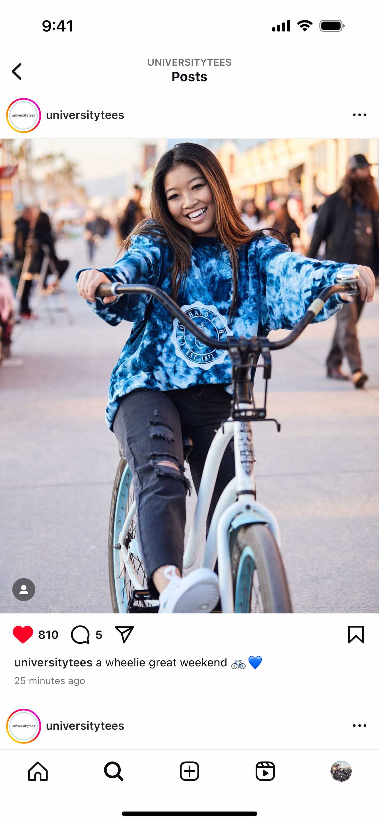 Instagram post by University Tees featuring a lifestyle campaign photo of a young woman riding a bike on the Venice Beach boardwalk, wearing a blue tie-dye hoodie. The caption reads, "a wheelie great weekend" with a bicycle and heart emoji.