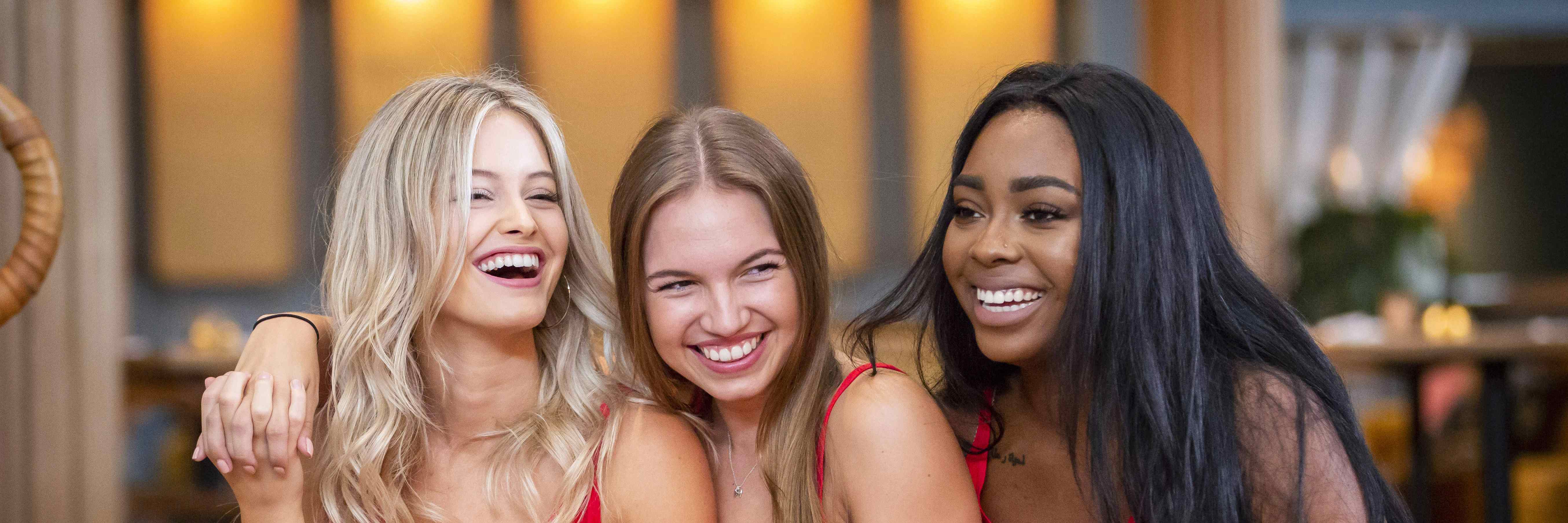 Three diverse young women laughing and enjoying a moment together in a relaxed setting