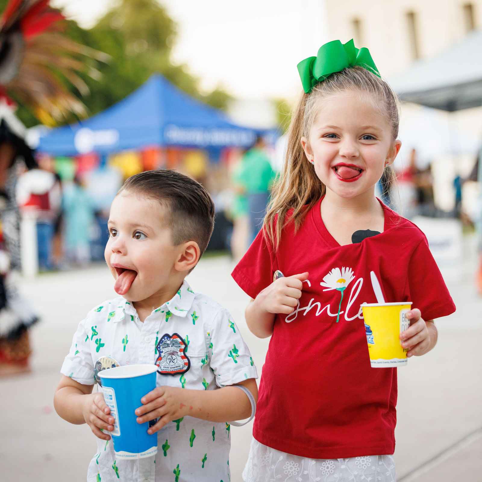 Young boy and girl enjoying slushies at a park event in Chandler, Arizona