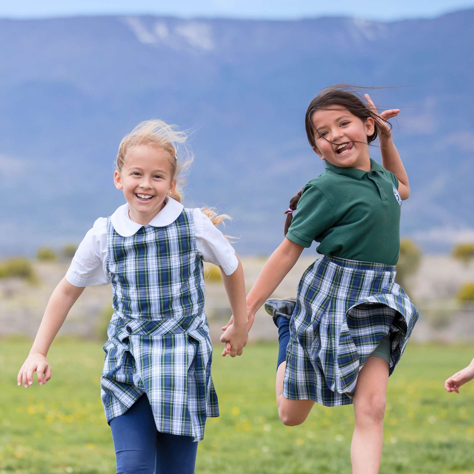 Smiling elementary students in uniforms running outside in Cottonwood, Arizona