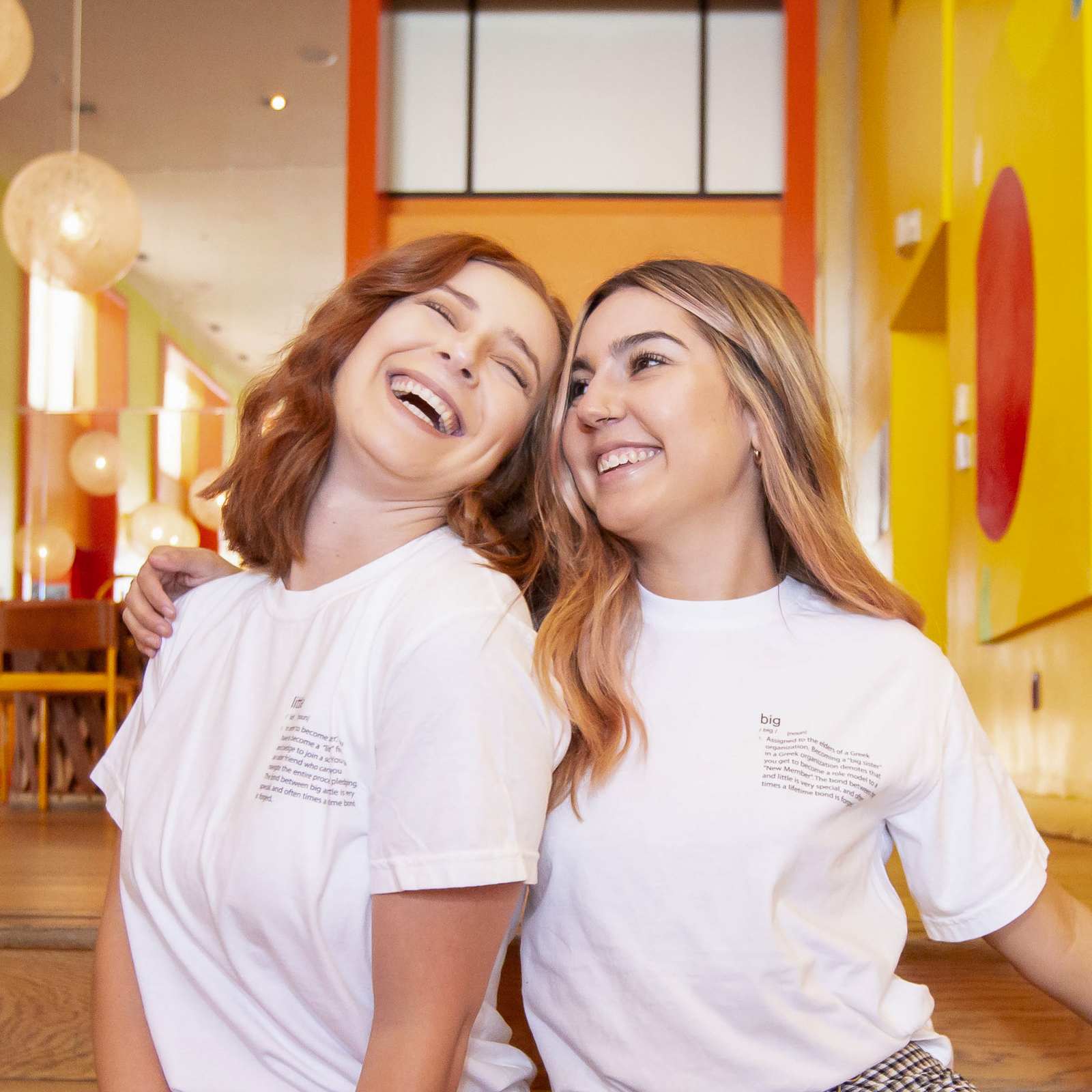 Two young women laughing together while sitting on stairs in Scottsdale, Arizona