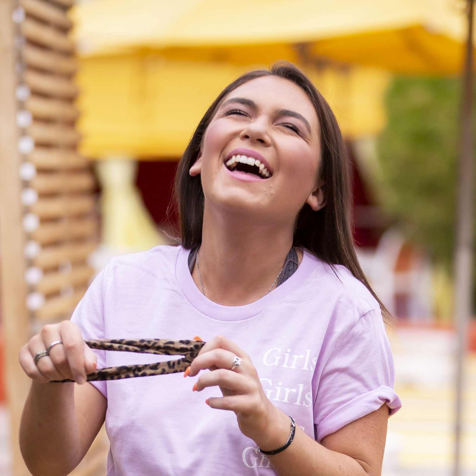 Young woman laughing near a poolside lounge area wearing a cheetah print skirt in Scottsdale, Arizona