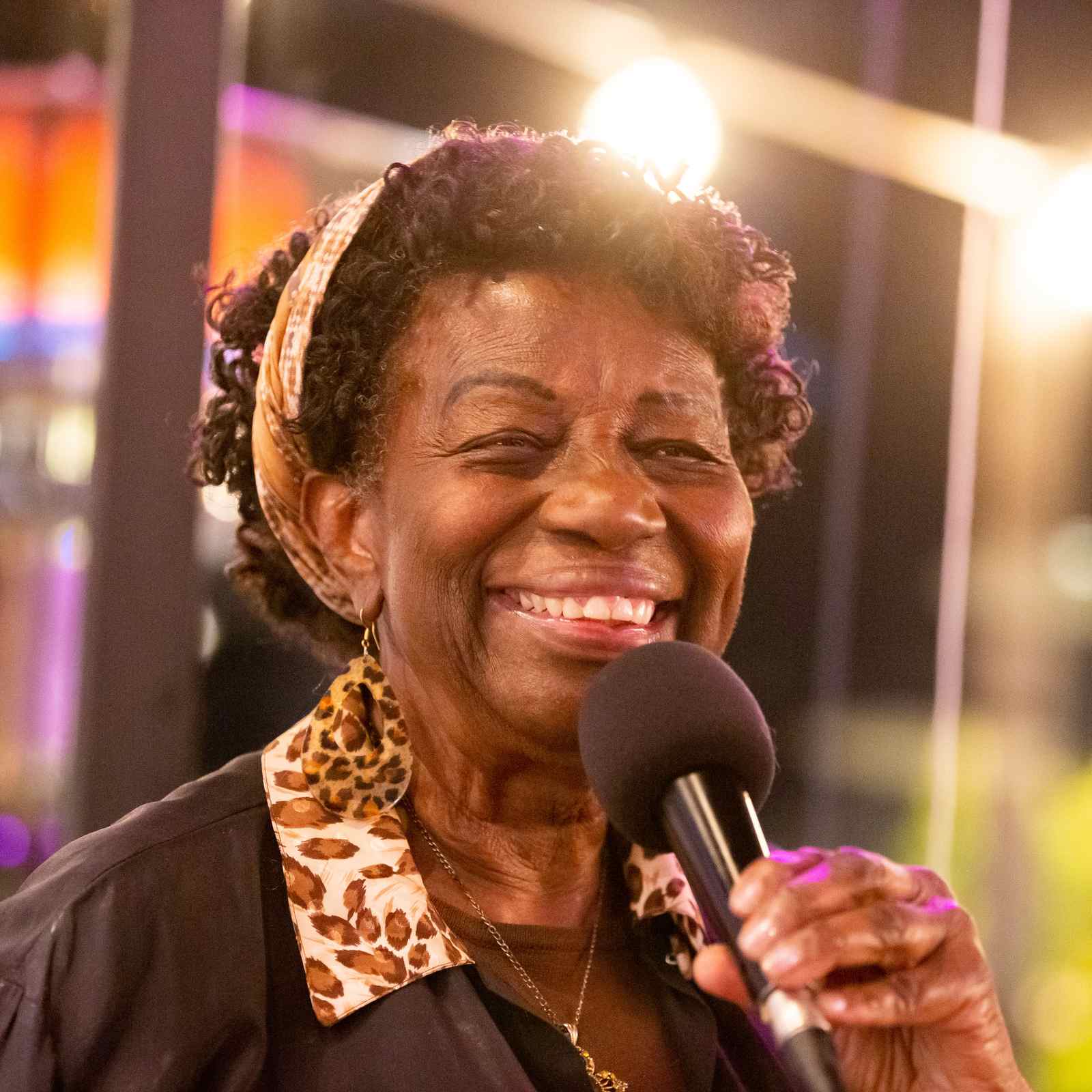 African American woman singing with a smile at a bar in Tempe Arizona