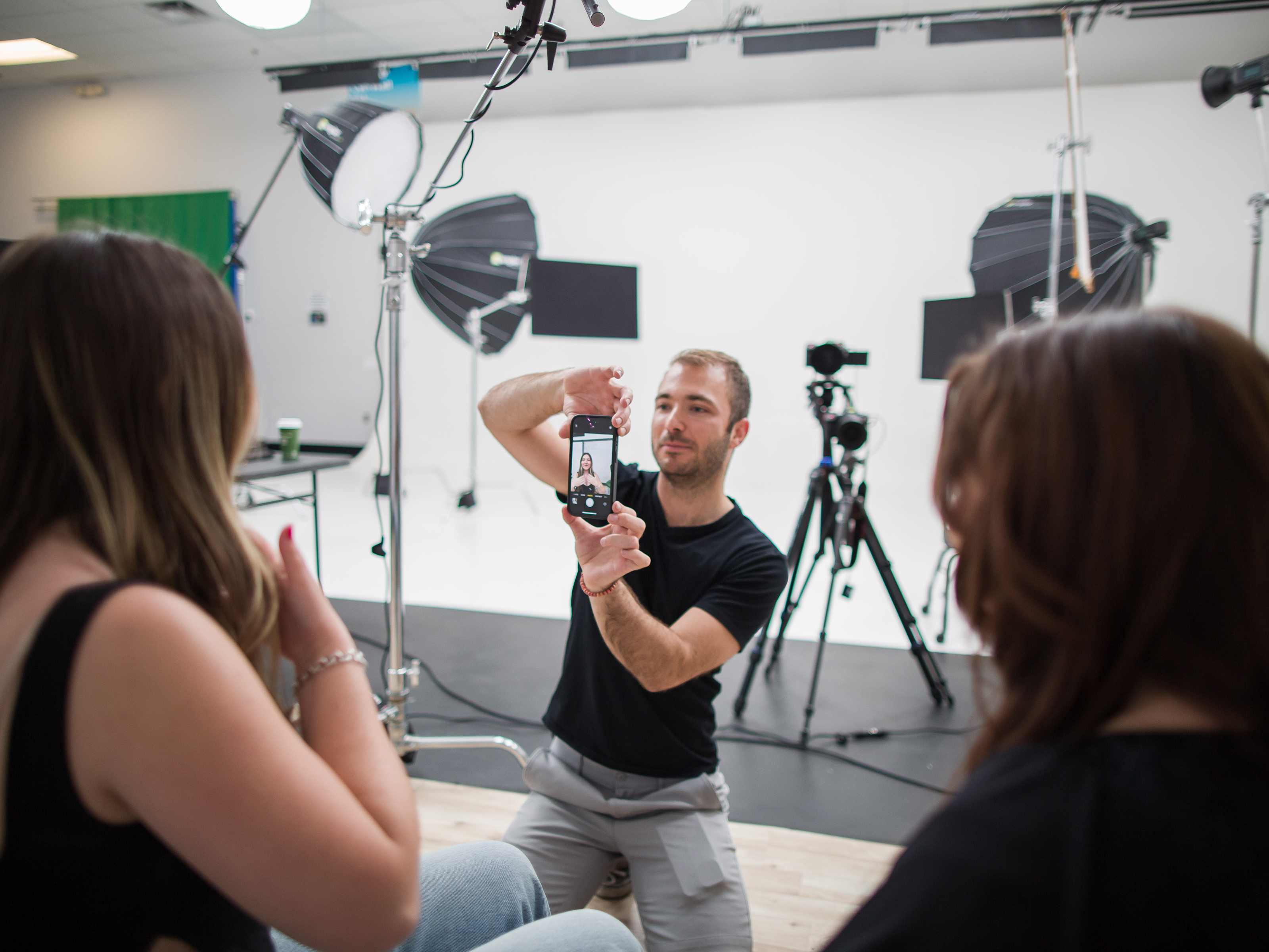 Billy Hardiman engaging with models in a large professional studio in Chandler